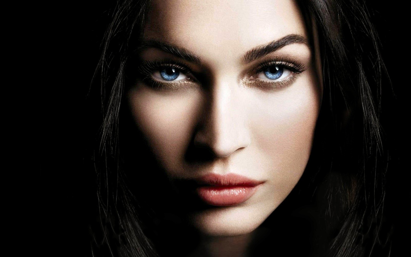 Un gros plan d'une femme aux yeux bleus et aux longs cheveux (megan fox, visage, sourcil, lèvre, nez)