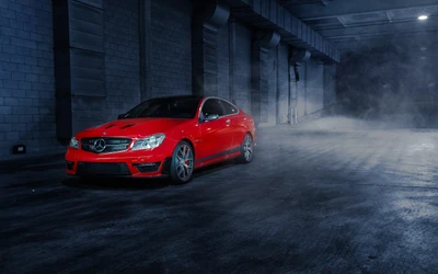 Mercedes-Benz C 63 AMG en un entorno urbano ahumado, mostrando llantas de aleación llamativas y un acabado rojo audaz.