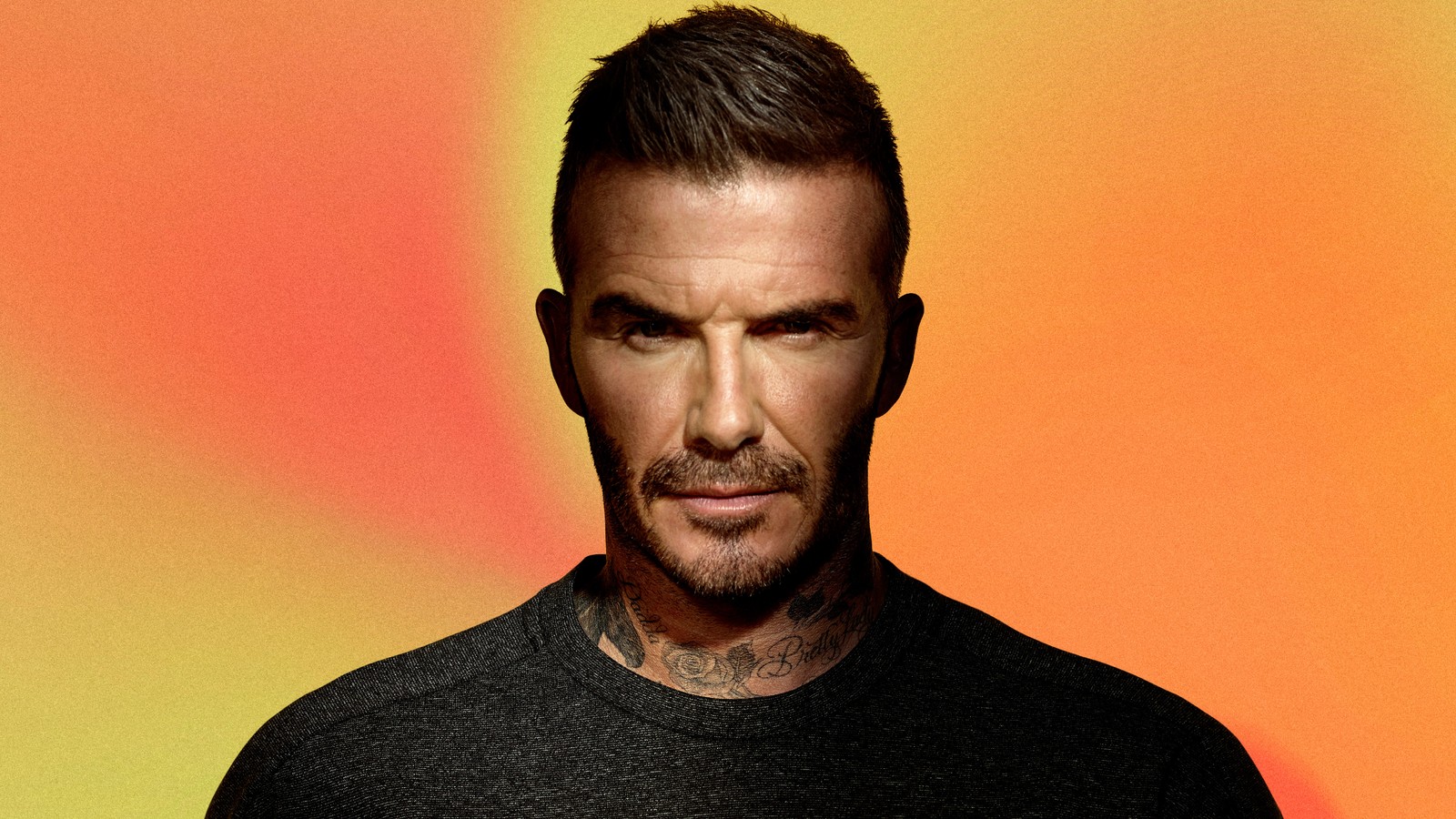 Un primer plano de un hombre con barba y camisa negra (david beckham, cabello, rostro, vello facial, mentón)