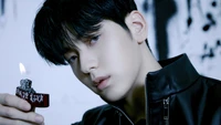 Soobin from Tomorrow X Together, exuding charisma and intensity, holds a lit lighter against a moody backdrop, embodying the themes of "Good Boy Gone Bad.