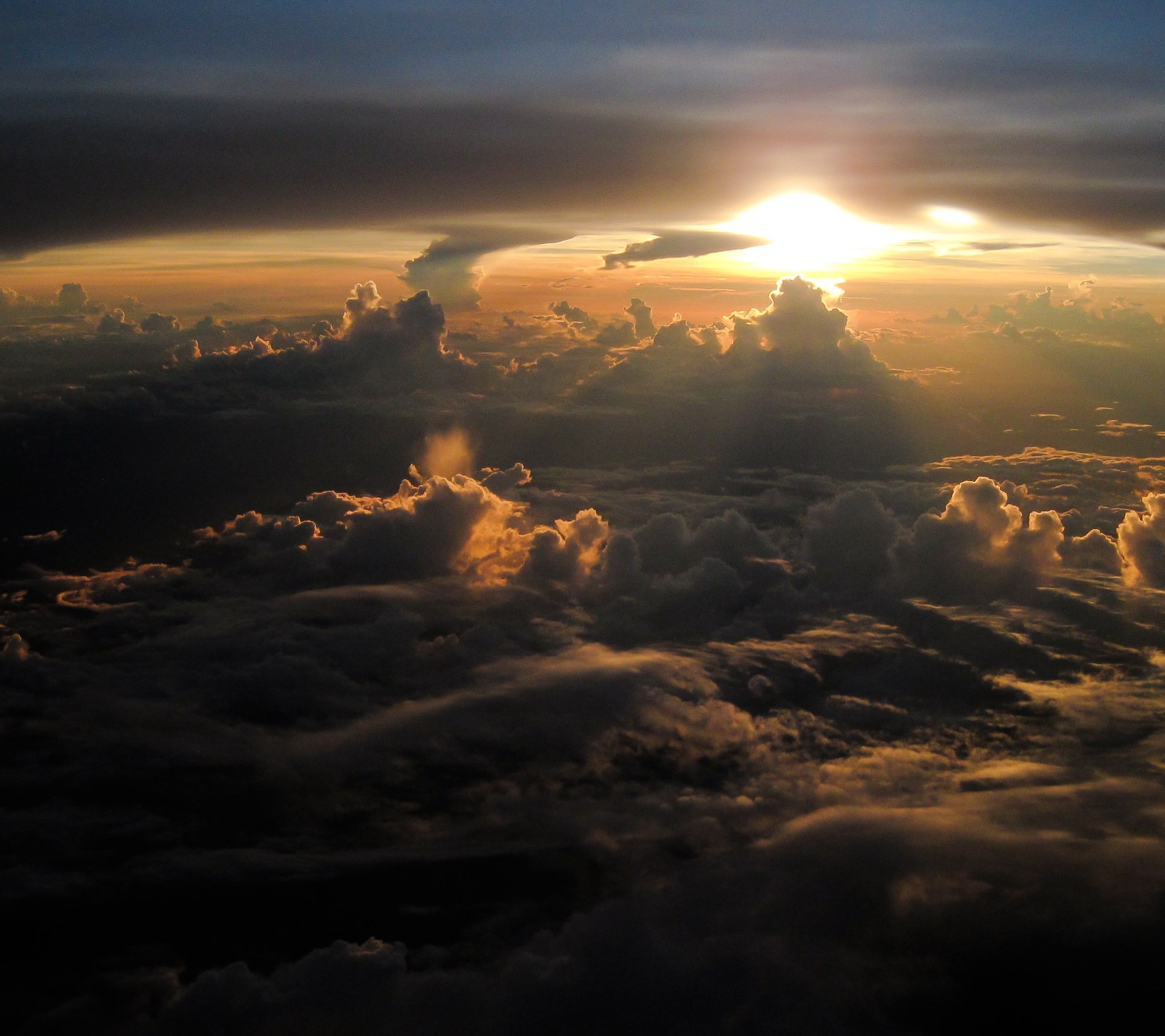 Vue d'un coucher de soleil au-dessus des nuages depuis un avion (nuage, ciel, soleil)