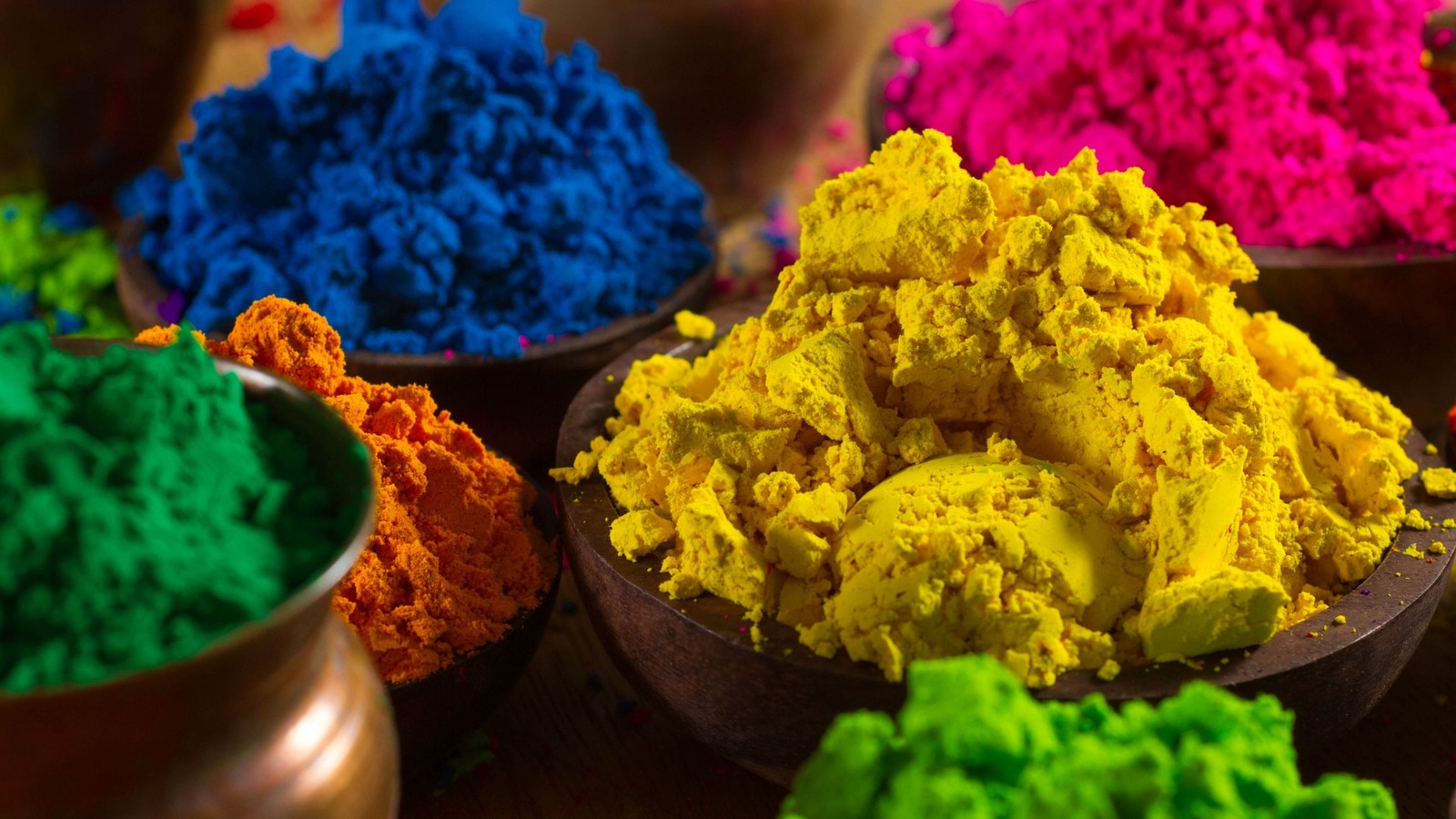 A close up of a bowl of colored powder on a table (color, happy holi, rangoli, splash)