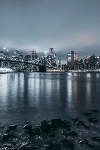 Paisaje urbano de Brooklyn de noche: reflejos iluminados del horizonte en el agua