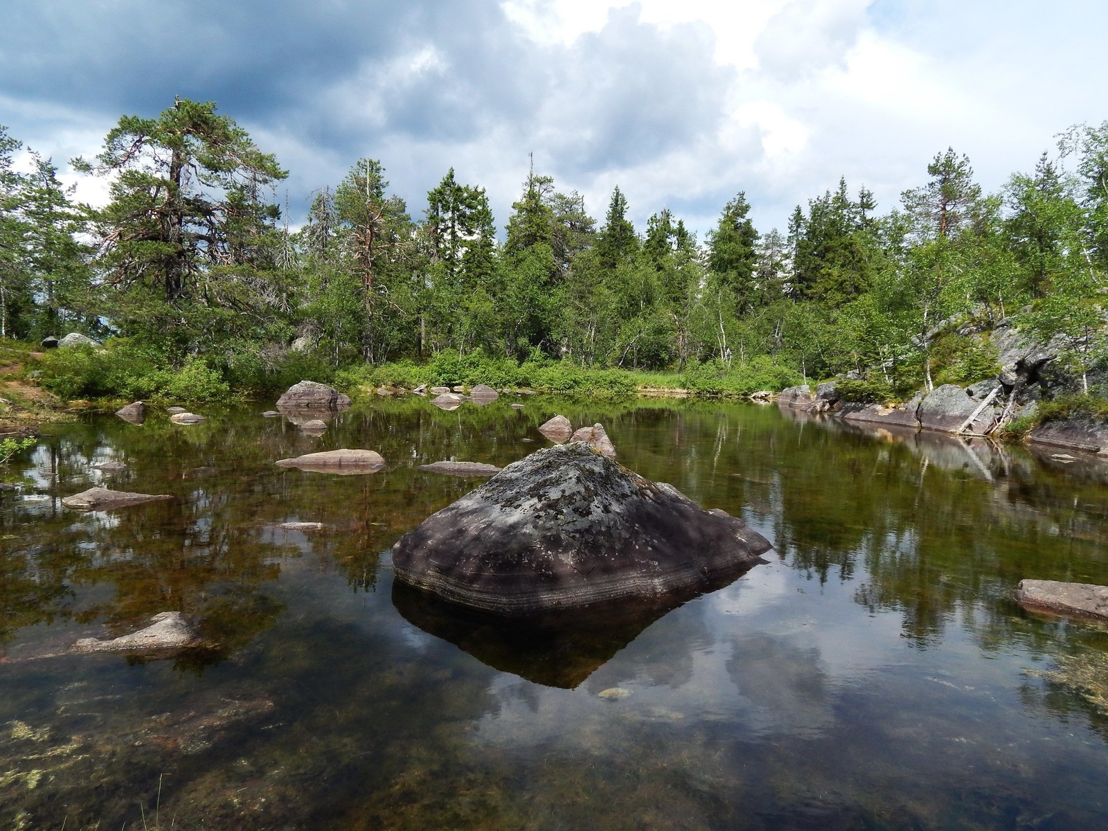 Hay una gran roca en el medio de un pequeño río (reserva natural, naturaleza, agua, reflexión, recursos hídricos)