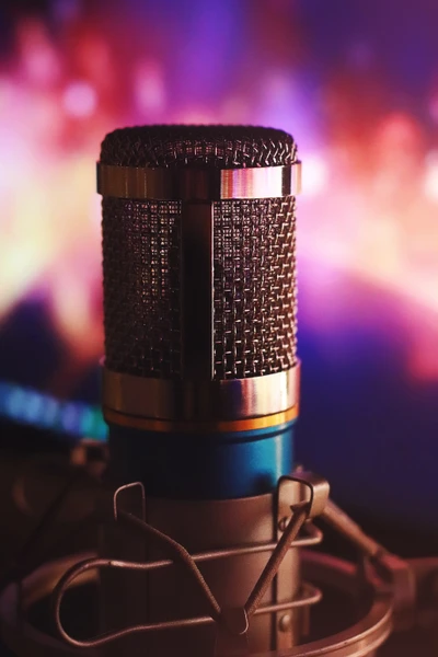 Close-up of a microphone in a recording studio, with a colorful background highlighting audio technology and sound recording.