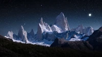 Noite estrelada sobre picos de montanhas nevadas