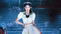 Irene de Red Velvet dans une tenue inspirée des marins, dégageant une aura cosmique et mystérieuse sur un fond faiblement éclairé.