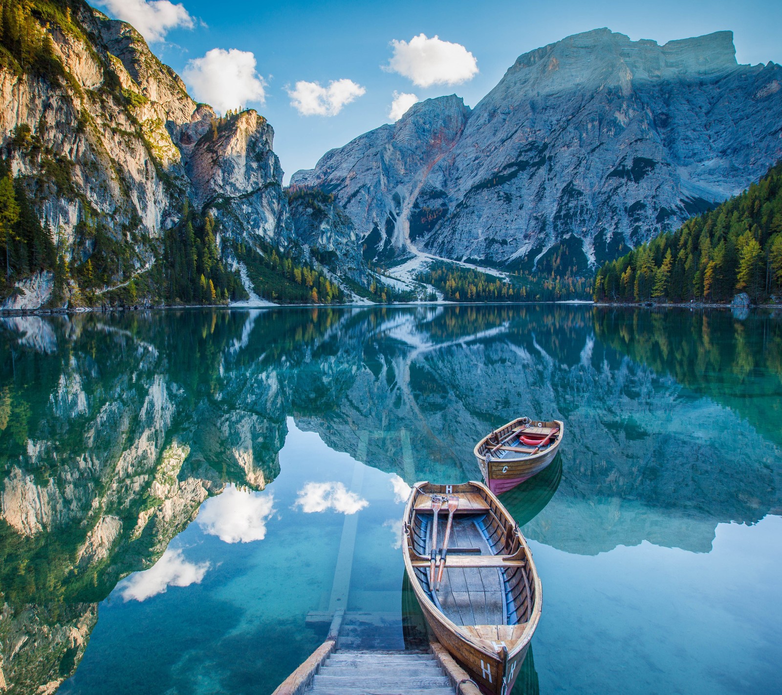 Barcos atracados em um cais em um lago com montanhas ao fundo (barcos, lago, espelho, montanhas, reflexo)