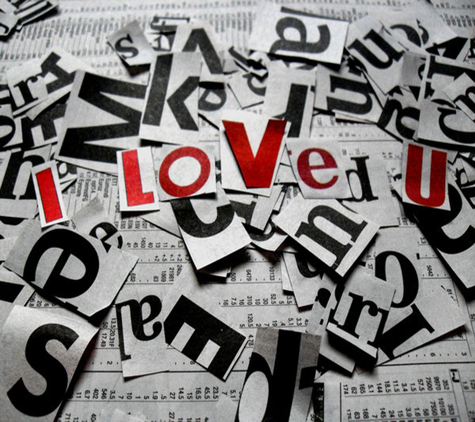 A close up of a pile of newspaper with the word i love u (love, te amo)