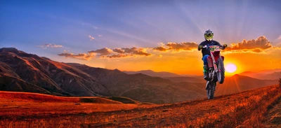 Motocross Rider Performing a Wheelie at Sunset in Mountain Landscape