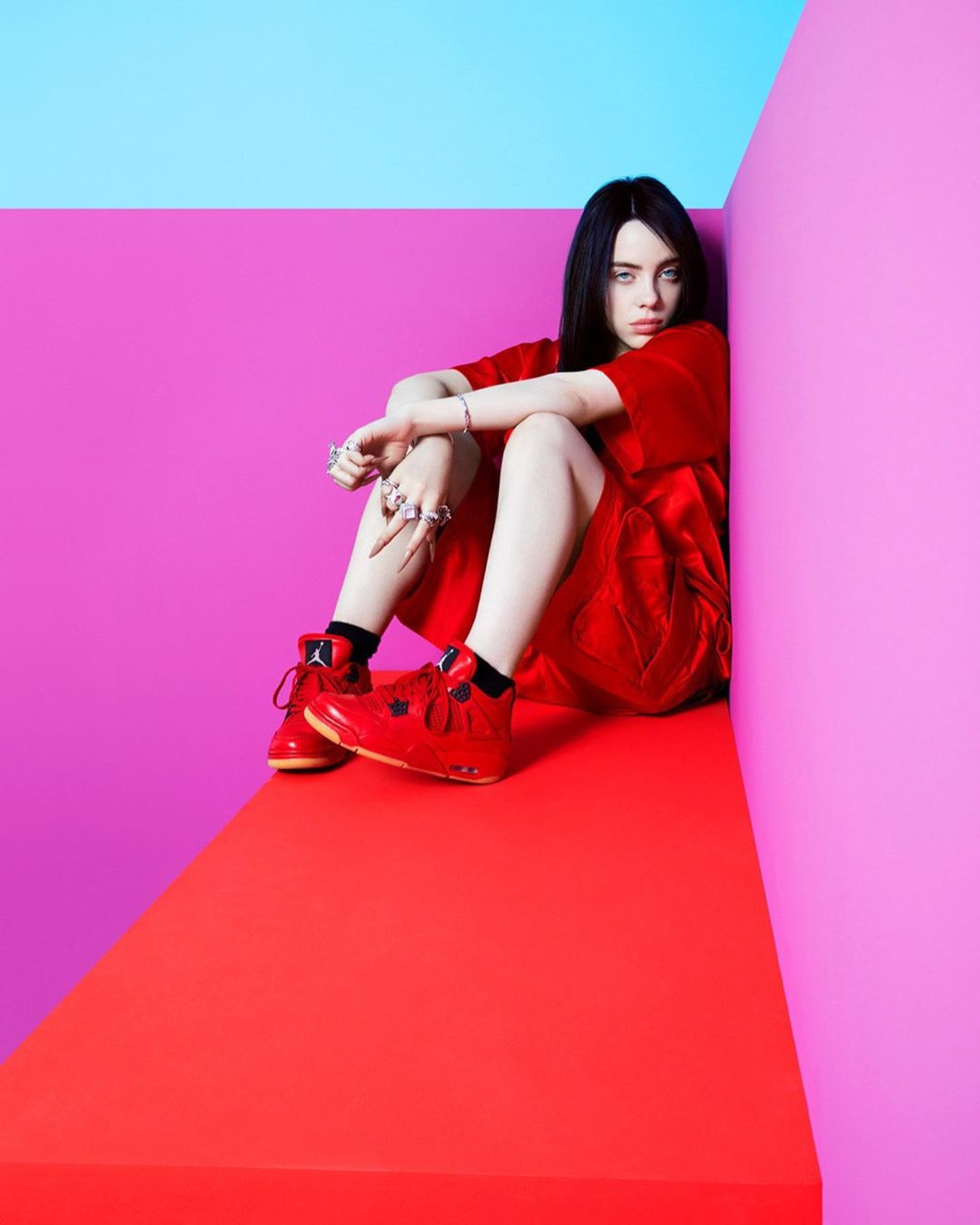 Arafed woman in red dress sitting on a red and pink platform (billie, billie eilish, billieeilish, eilish)