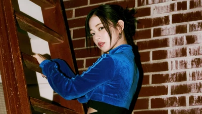 Lee Chaeyoung de fromis_9 dans une tenue bleue frappante contre un mur en briques texturé