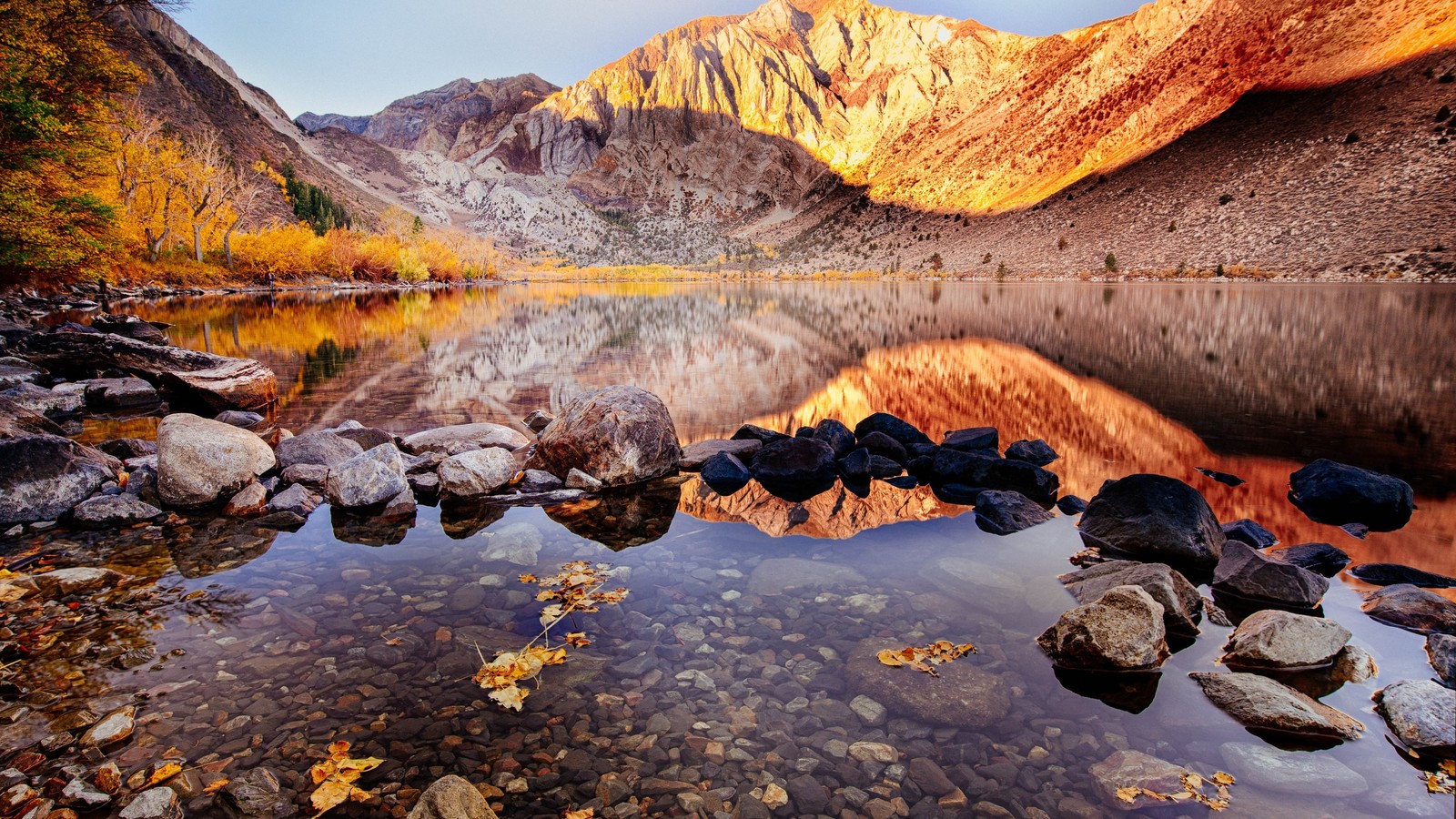 Una vista de un lago de montaña con rocas y agua en primer plano (reflexión, naturaleza, desierto, roca, montaña)