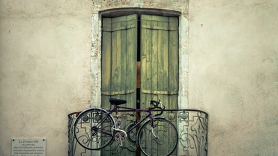 Vintage Bicycle Resting on a Balcony Below a Rustic Door