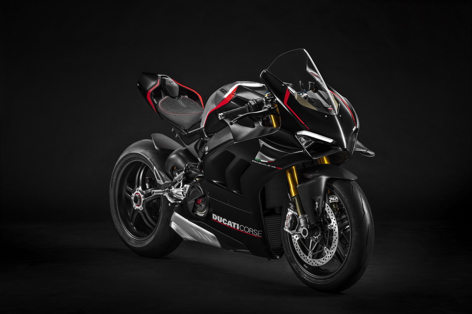 Un primer plano de una motocicleta aparcada en una habitación oscura (ducati panigale v4 sp, 8k, 2021, fondo oscuro, 5k)