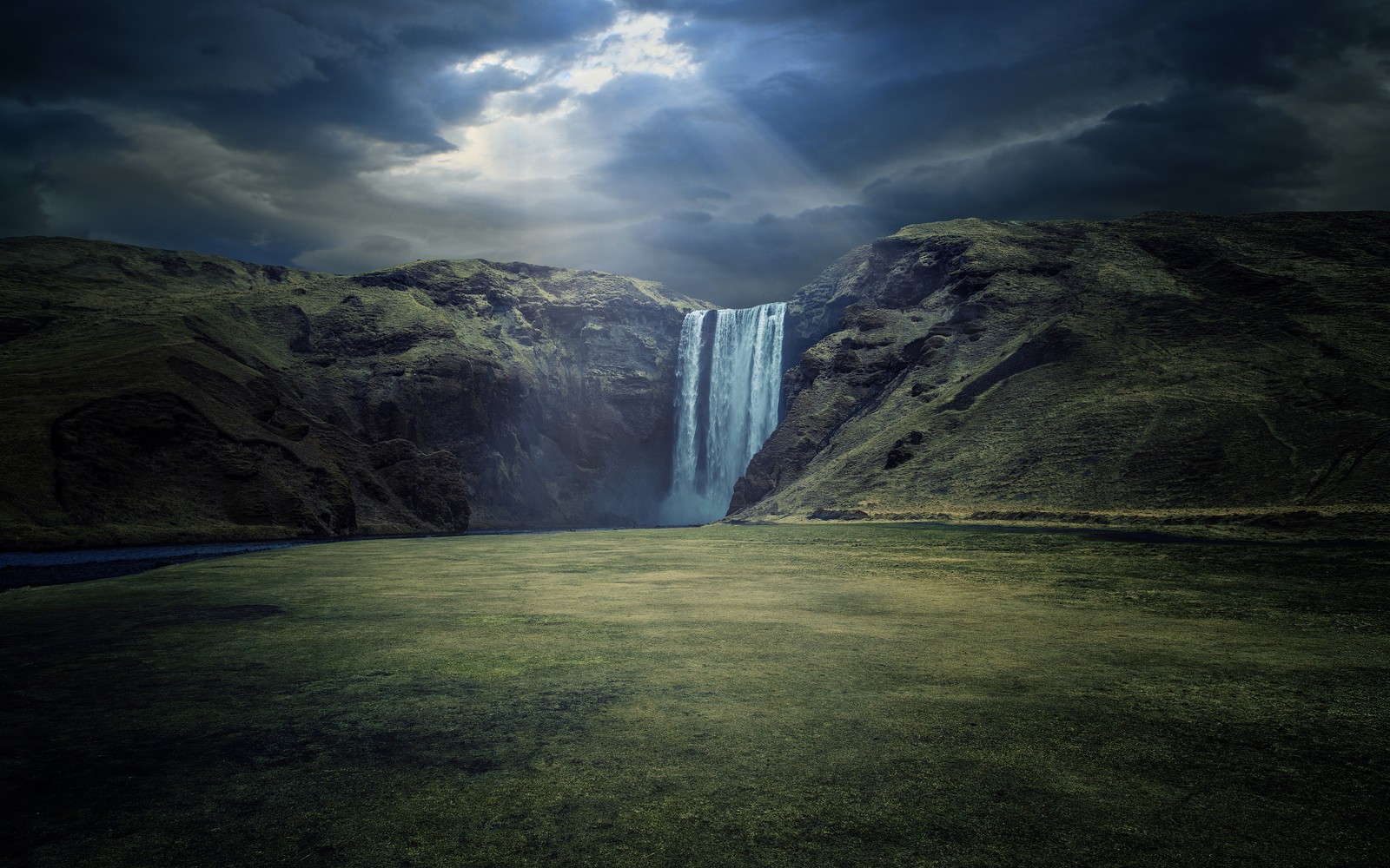 Uma grande cachoeira sai de um vale verde (skógafoss, cachoeiras, islândia, falésias, raios de sol)