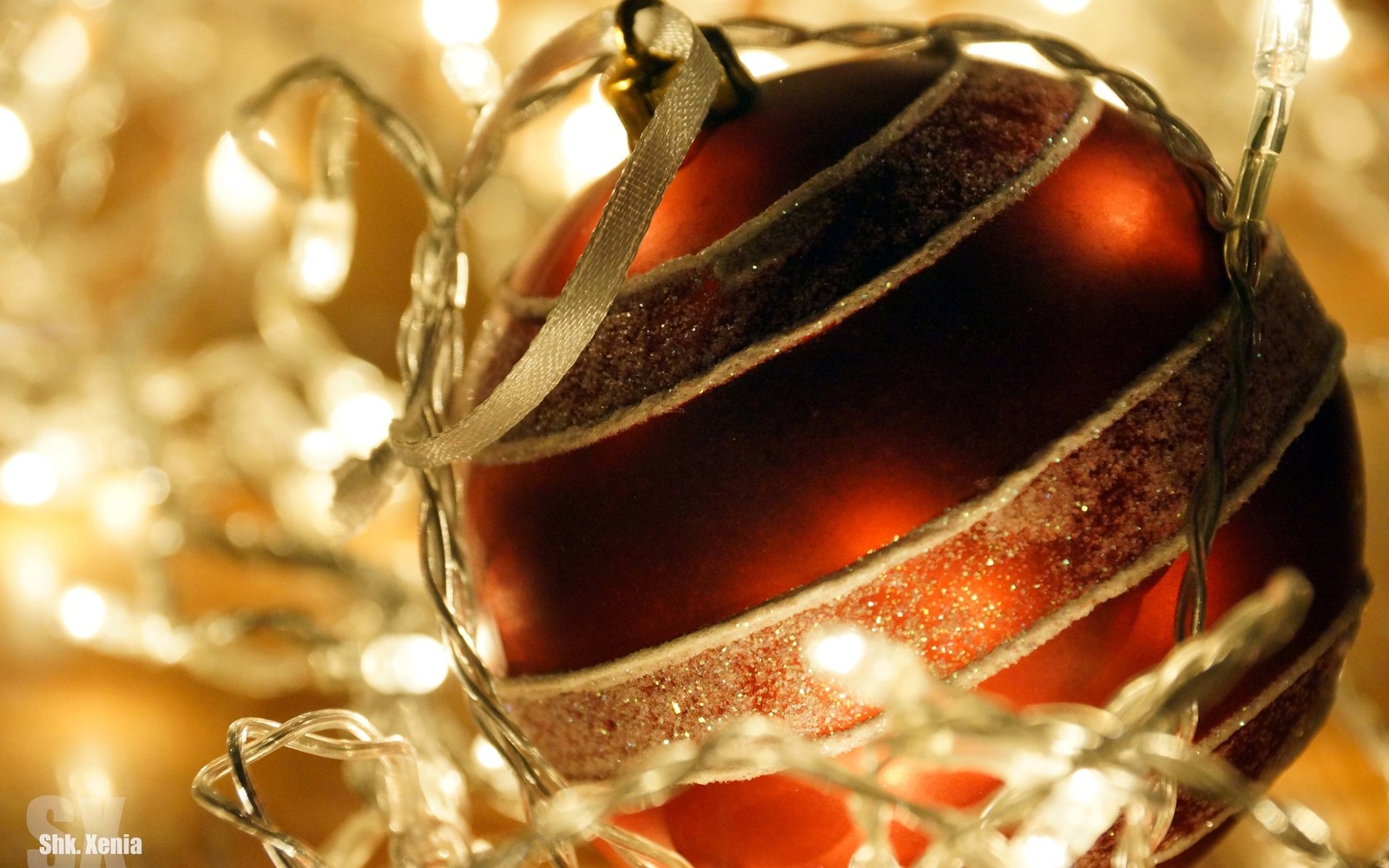 A close up of a red and silver christmas ornament with a ribbon (new year, holiday, christmas ornament, christmas decoration, christmas)