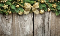 Elegant Christmas Decoration with Evergreen Branches and Golden Ornaments on Rustic Wood Background