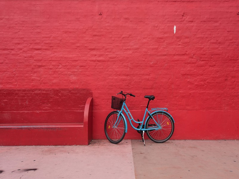 Арафированный велосипед leaning against a red wall with a bench (велосипед, красный, стена)