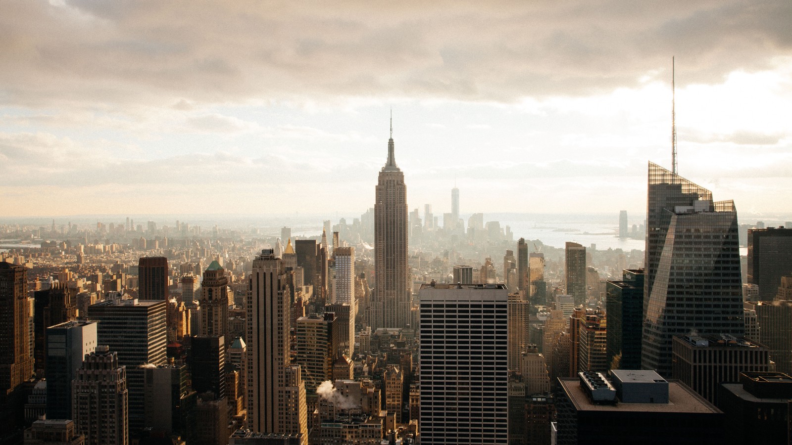 Imagen borrosa de una ciudad con rascacielos y un cielo nublado (nueva york, new york city, nube, rascacielos, edificio)