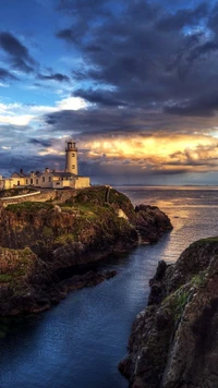 Farol ao crepúsculo com vista para a costa irlandesa