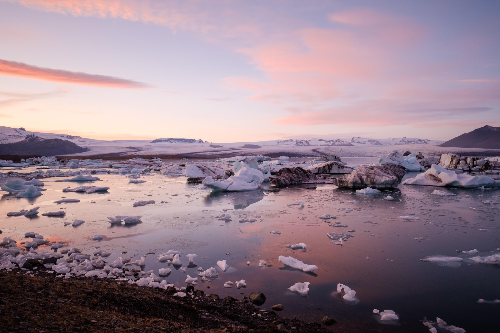 Una vista de un cuerpo de agua con hielo flotando en él (reflexión, mañana, hielo marino, iceberg, océano ártico)