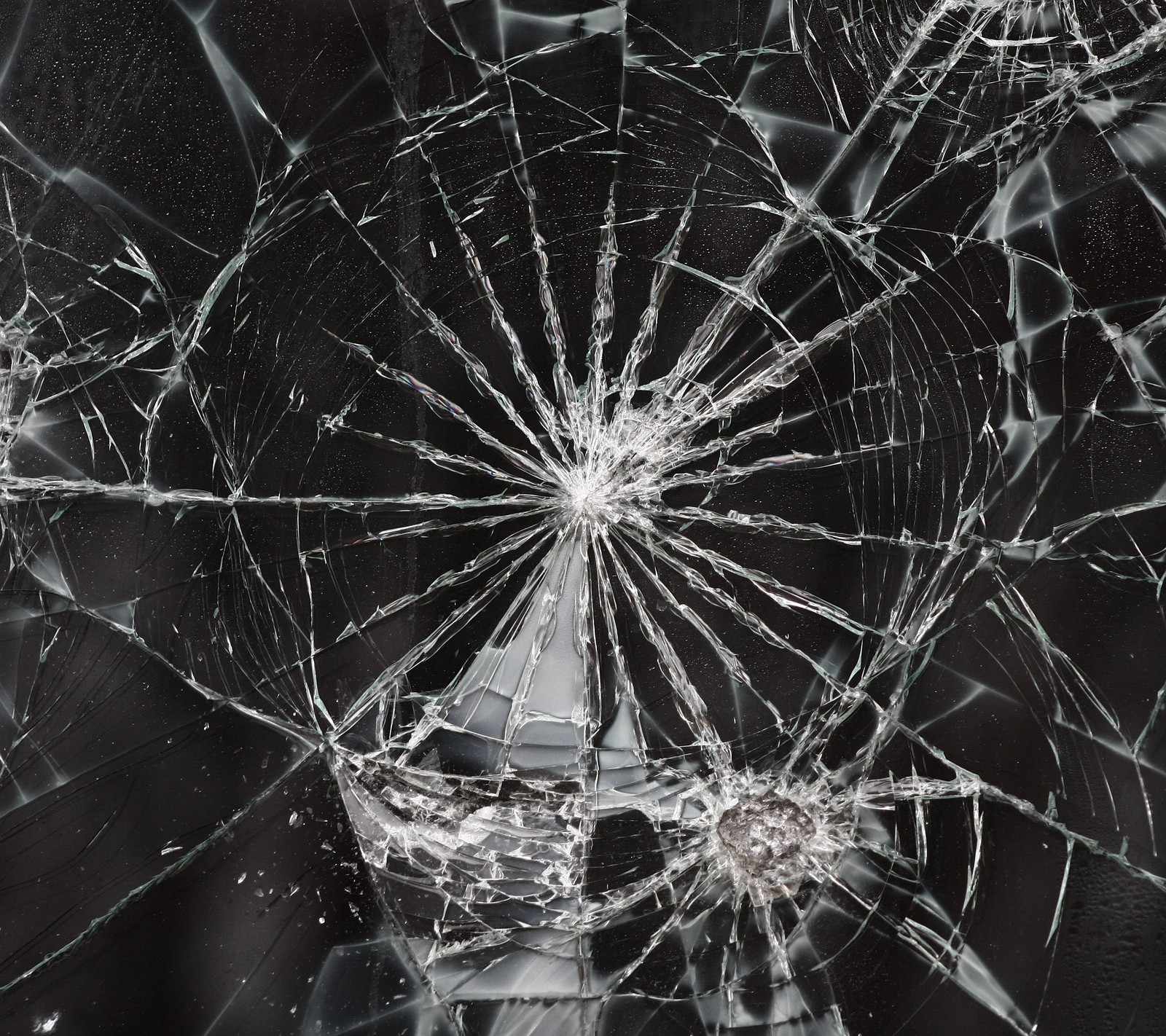 A close up of a broken glass window with a black background (broken screen, cracks, surface, texture)