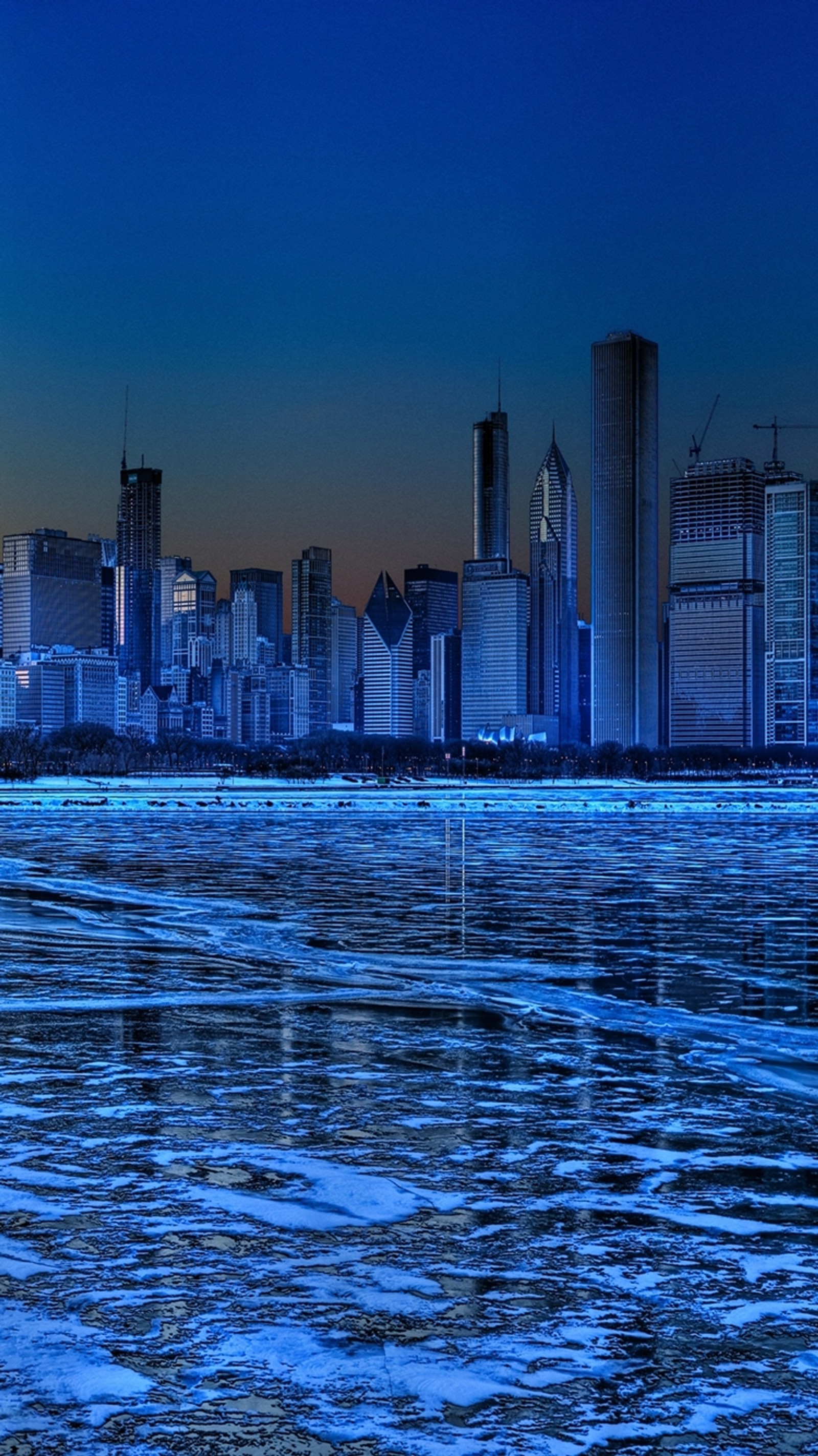 Una vista del horizonte de la ciudad con un lago congelado en primer plano (edificio, chicago, ciudad, congelar, hielo)