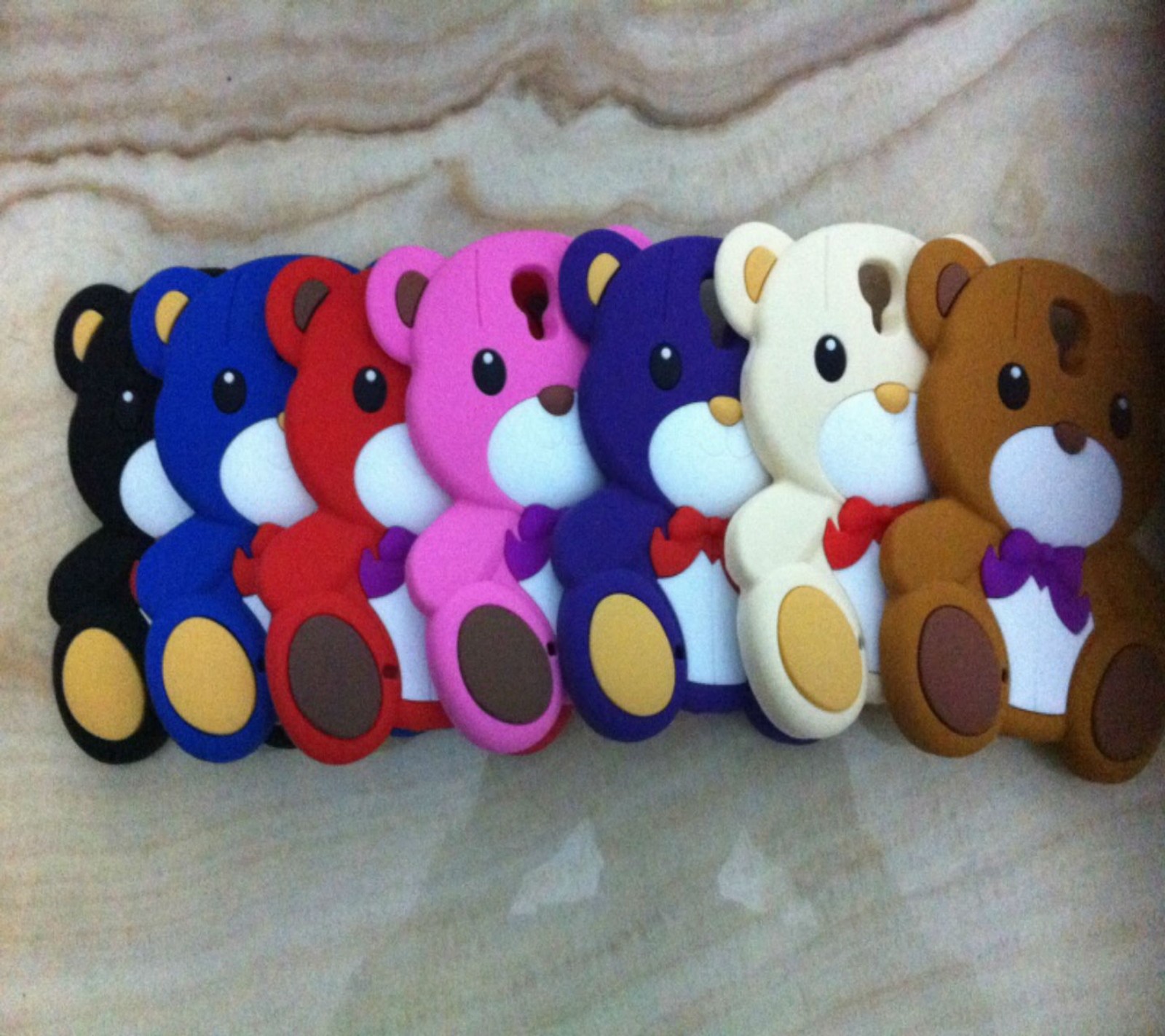 There are many different colored teddy bears sitting together on a table (2014, 3d, background, colorful, cool)