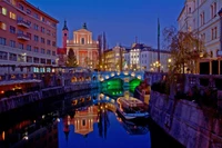 Reflexión nocturna del canal y el paisaje urbano de Ljubljana