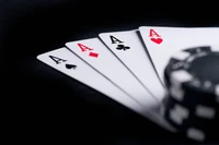 Mão vencedora: quatro ases e uma ficha de poker