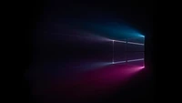 Art numérique Windows 10 avec des rayons de lumière colorés sur un fond noir