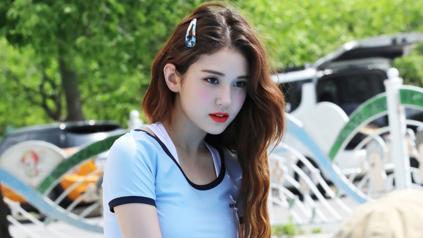 Una chica con labios rojos y una camiseta azul posando para una foto (somi, 소미, ennik somi douma, jeon somi, jeon so mi)