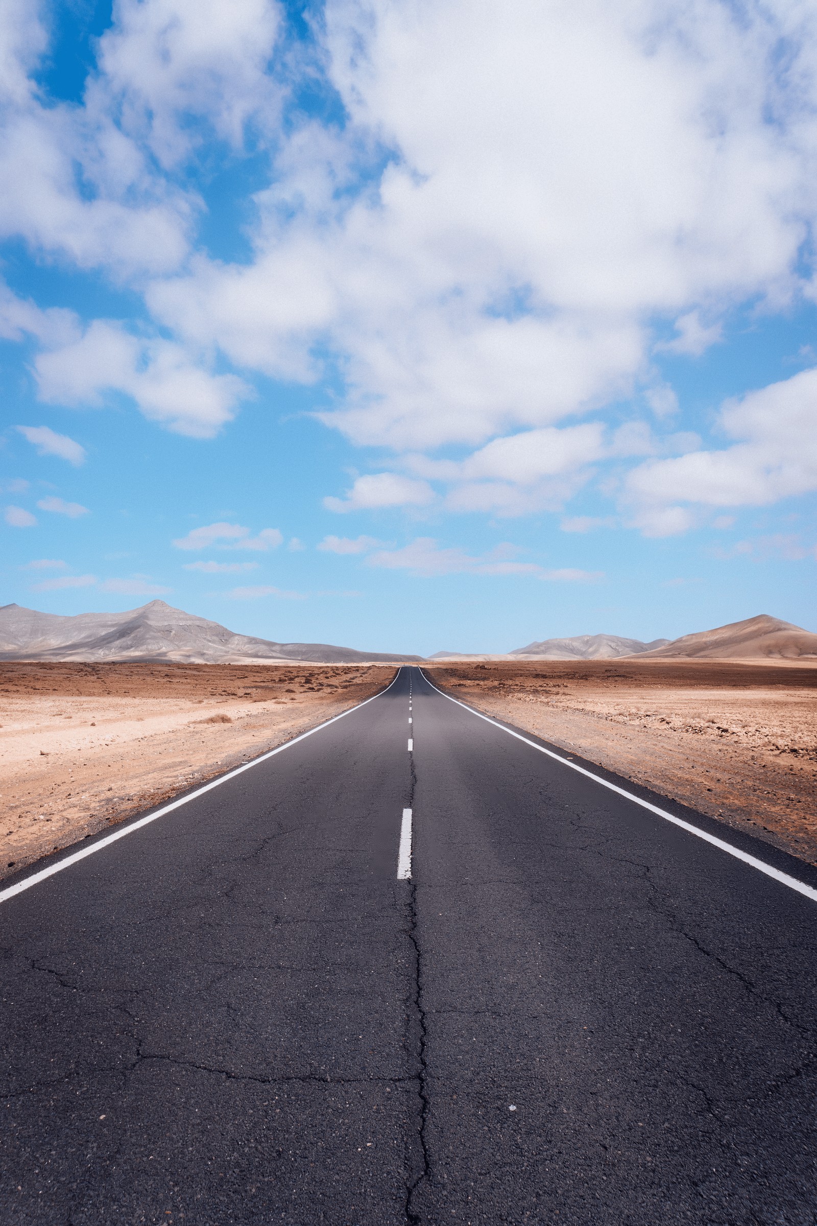 En la imagen hay una larga carretera vacía en medio del desierto (camino, nube, superficie de la carretera, asfalto, paisaje natural)