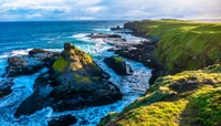 Punta costera vibrante con formaciones rocosas escarpadas y aguas turquesas