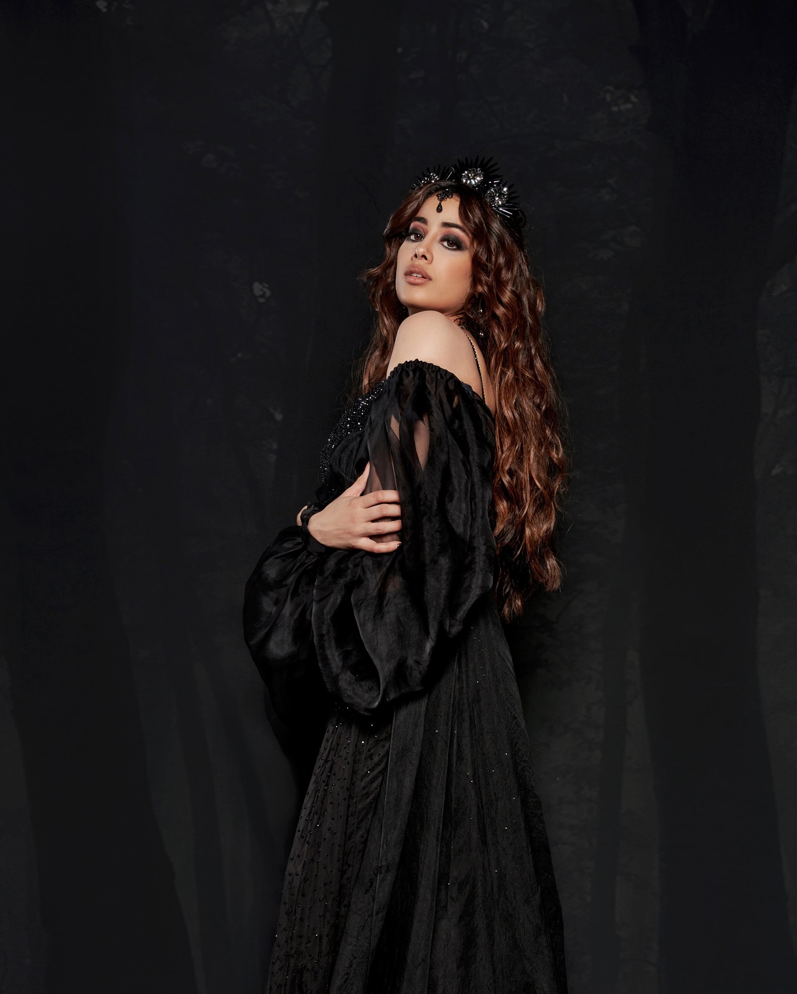 Femme arabe en robe noire posant devant un fond noir (janhvi kapoor, actrice, actrice de bollywood, actrice indienne, séance photo)