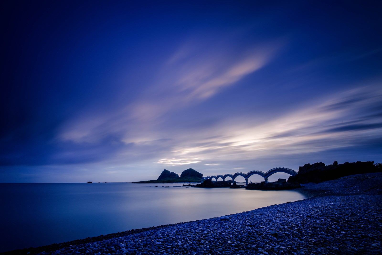 A view of a bridge over a body of water at night (sunset, sea, blue, nature, water)