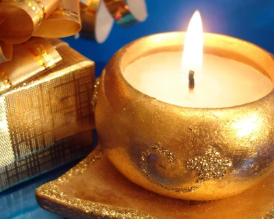 Elegante goldene Kerze mit warmem Licht und Geschenkbox-Akzent