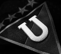 Emblema de LDU Quito: Escudo negro y plateado con símbolo 'U