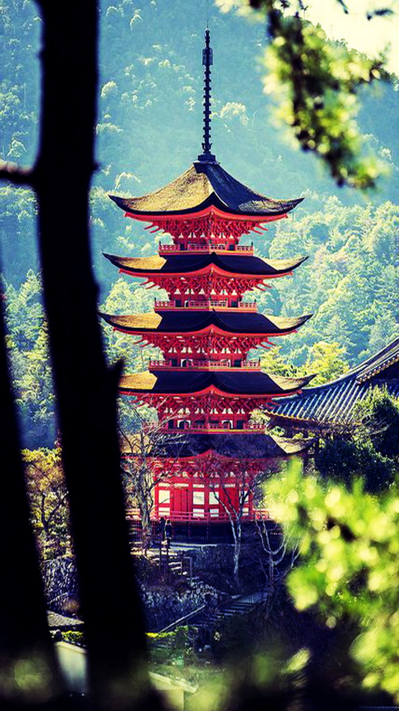 Pagode arafed au milieu d'une forêt avec une montagne en arrière-plan (japon, miyajima)