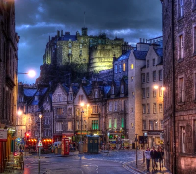 Castillo de Edimburgo iluminado sobre calles históricas al anochecer