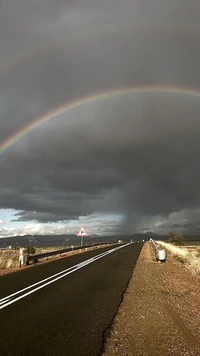 Rainbow Arcing Over Rainy Road