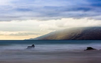 Côte sereine d'Oahu avec des montagnes brumeuses et des vagues douces