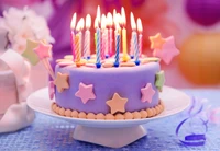 Pastel de cumpleaños colorido adornado con velas y estrellas decorativas, perfecto para la celebración de un niño.