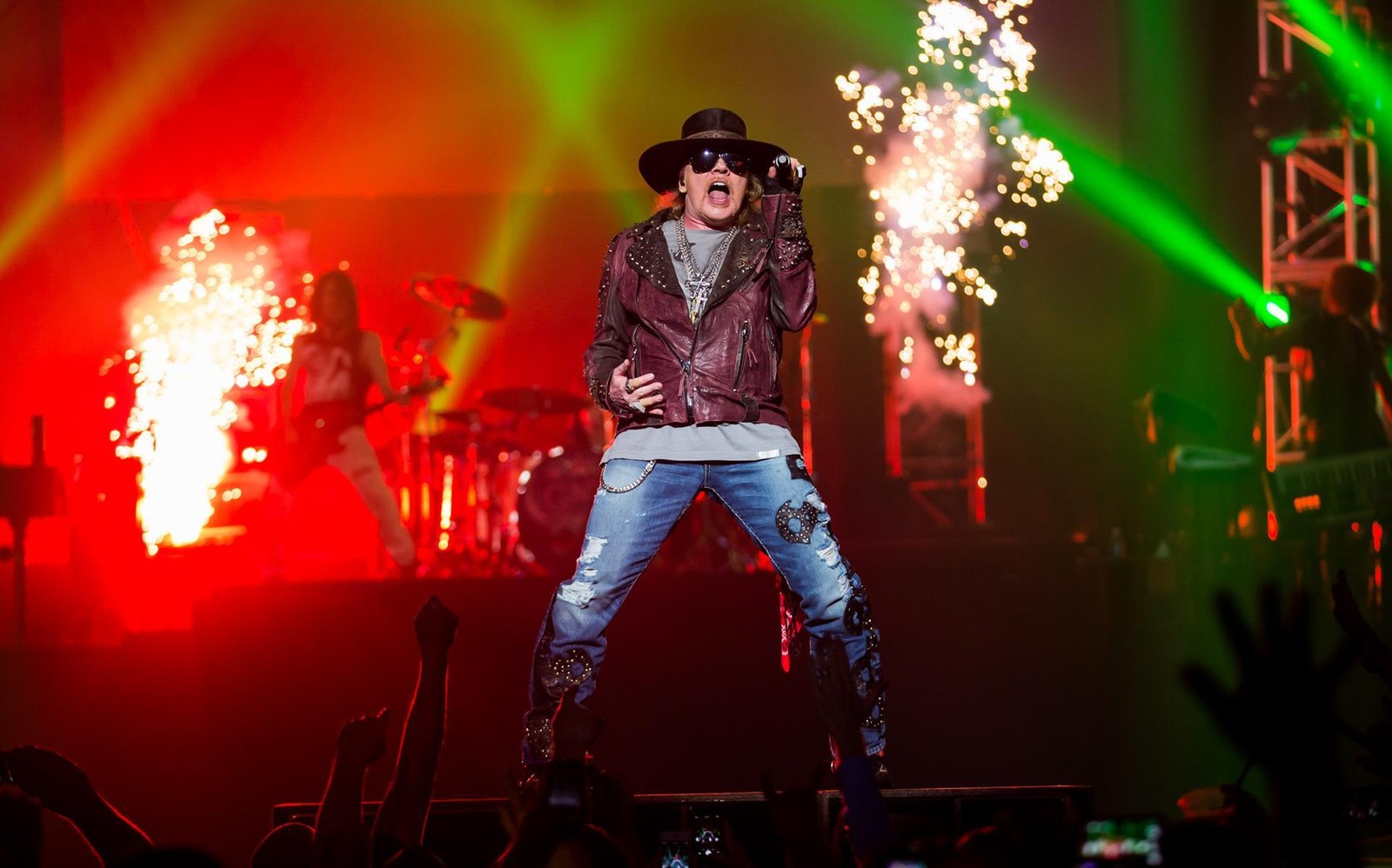 Araffes, a man in a hat and sunglasses, is singing on stage (rock concert, musician, guns n roses, guitarist, musical ensemble)