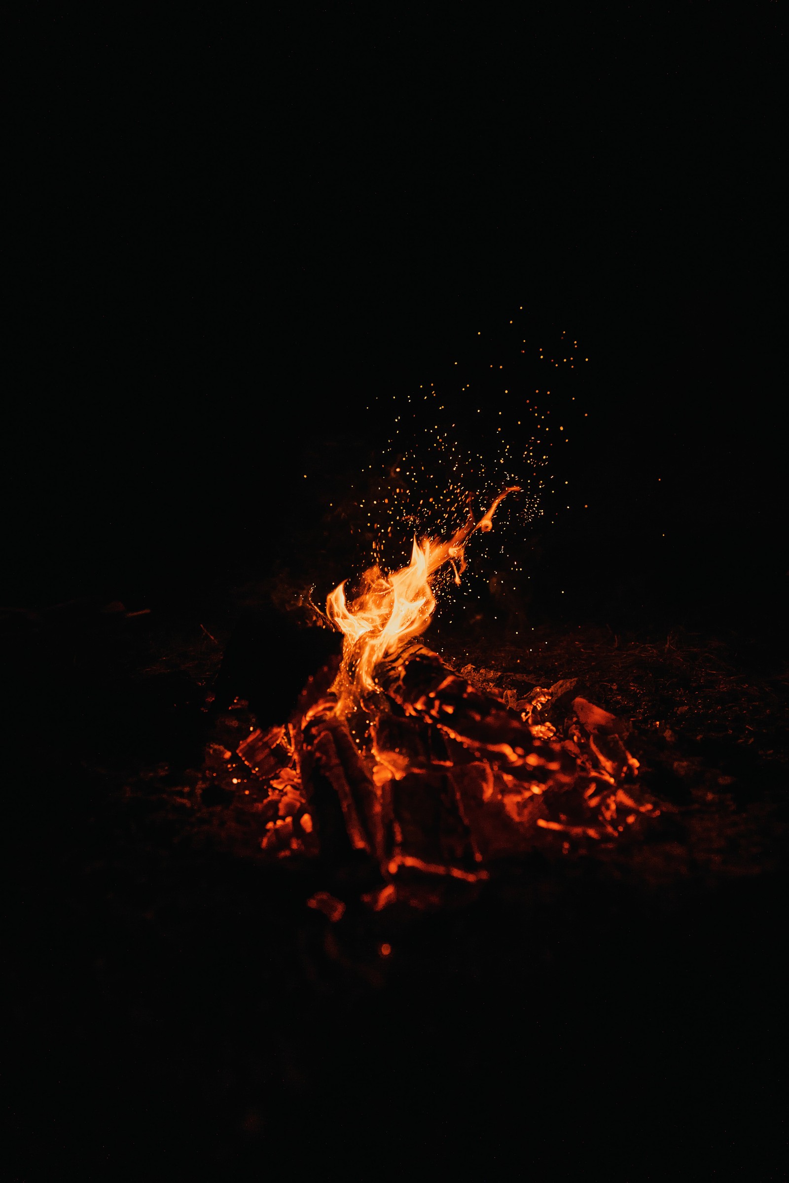 Há um fogo queimando na escuridão (fogueira, escuro, fundo preto, chama, tempo noturno)