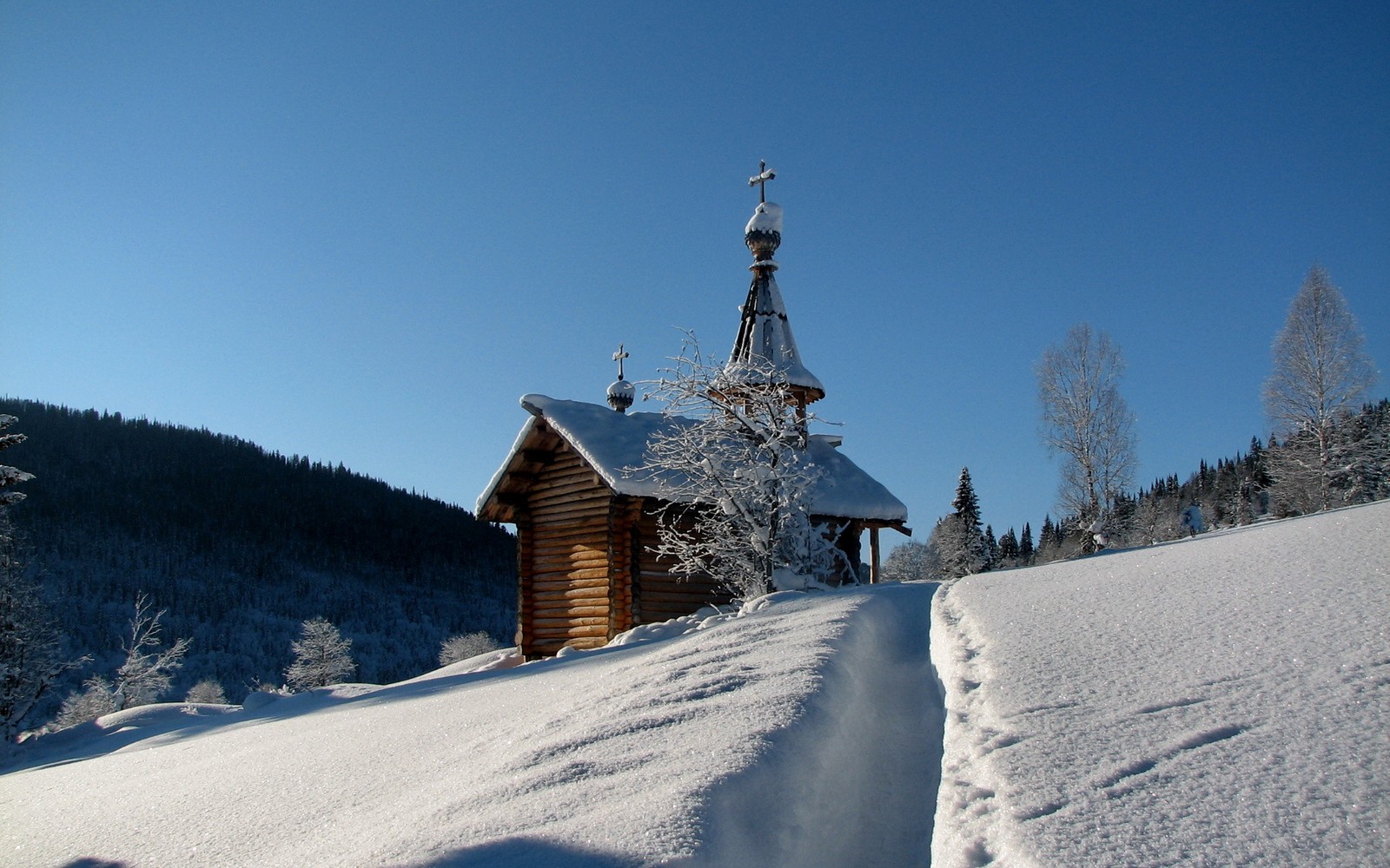 Snowy scene of a small church with a steeple and a steeple (snow, winter, freezing, tree, mountain)