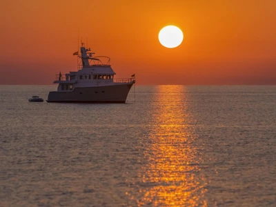 Serene Sunset Over the Horizon with a Ship at Sea