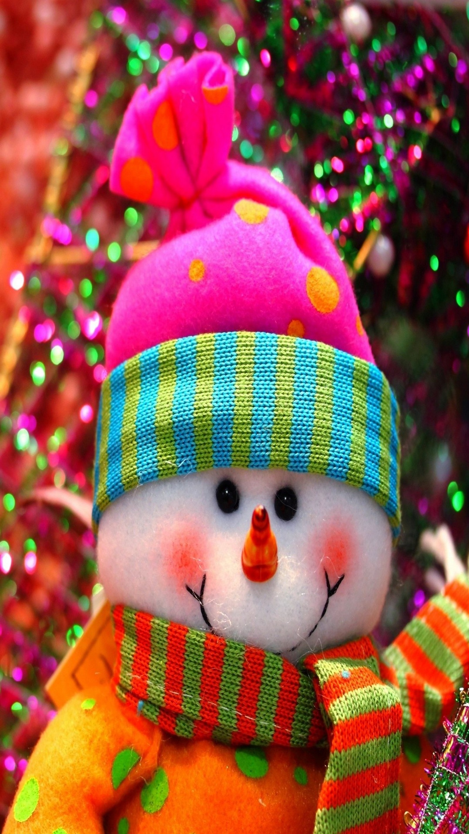 Un bonhomme de neige coloré avec une écharpe et un chapeau colorés sur un sapin de noël (noël, bonhomme de neige)