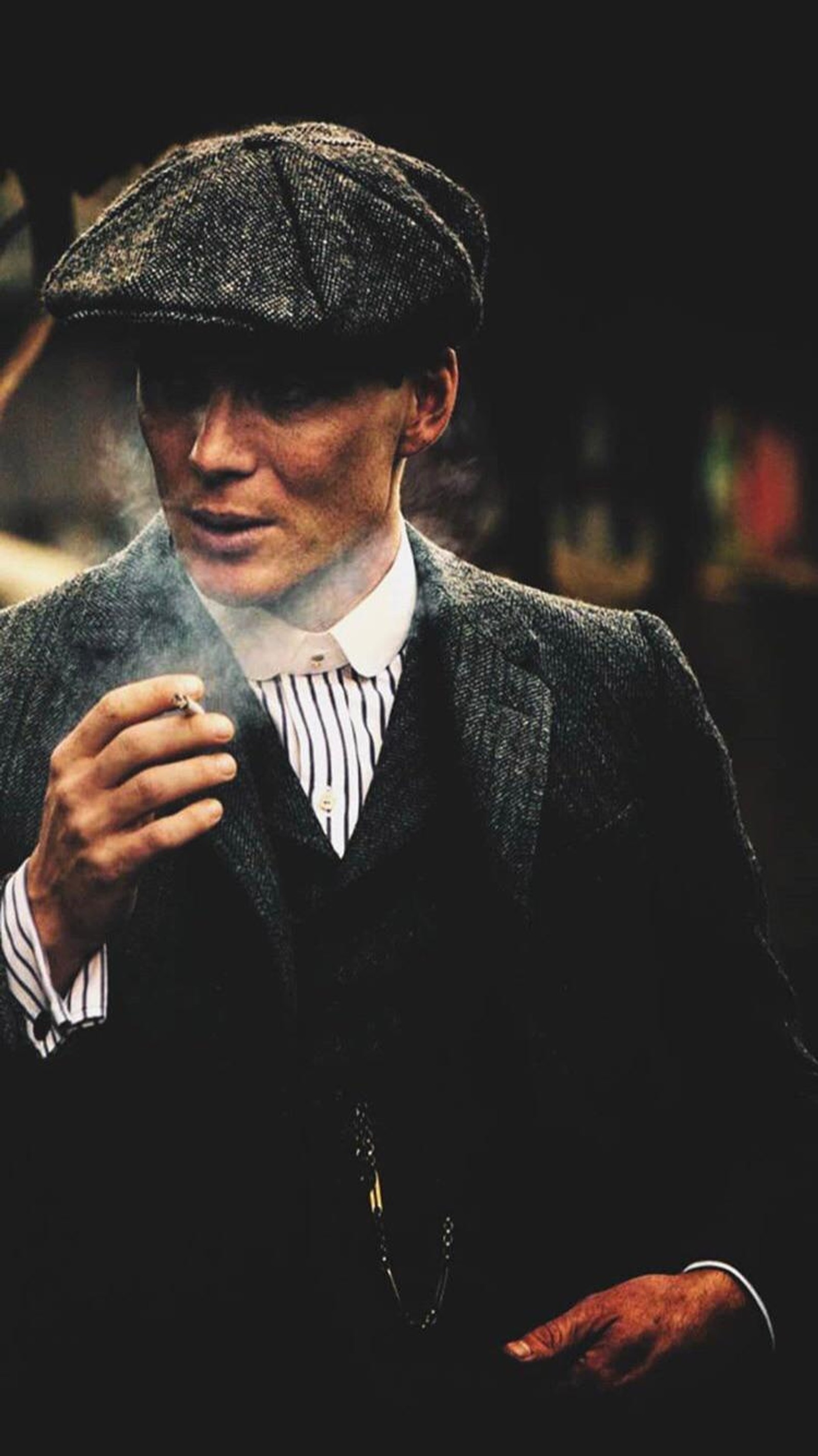 Há um homem de terno fumando um cigarro (dizi, filme, netflix, peaky blenders, shelby)